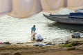 Indian man washing clothes in holy water of river Ganga in the morning. Varanasi. India Royalty Free Stock Photo