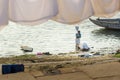 Indian man washing clothes in holy water of river Ganga in the morning. Varanasi. India Royalty Free Stock Photo