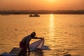 Indian man washing clothes in holy water of river Ganga in sunrise. Varanasi. India Royalty Free Stock Photo