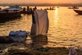 Indian man washing clothes in holy water of river Ganga in sunrise. Varanasi. India Royalty Free Stock Photo