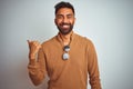 Indian man wearing elegant sweater and sunglasses standing over isolated white background smiling with happy face looking and Royalty Free Stock Photo