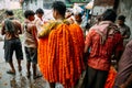 Indian man wearing marigold galant for sell at Mullick Ghat flower market in the morning in Kolkata, India Royalty Free Stock Photo