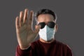 Indian Man wearing a N95 mask and sunglasses showing hands to stop virus, dust, pollution and smog