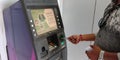 An indian man withdrawing money from ATM machine