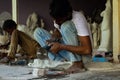 An Indian Marble Sculptor is sculpting a local Hindu deity with the help of modern grinding tool