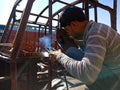 an indian mechanic belding on truck body during repairing work in India dec 2019