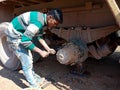 an indian mechanic boy opening truck wheel during repairing task at automobile workshop in India dec 2019 Royalty Free Stock Photo