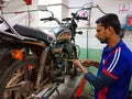an indian mechanic repairing hero bike at workshop in india January 2020