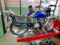 an indian mechanic repairing hero honda bike at service center in India January 2020