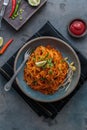 Indian mee goreng or mee goreng mamak, Indonesian and Malaysian cuisine, spicy fried noodles in a plate, top view Royalty Free Stock Photo