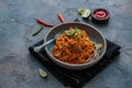 Indian mee goreng, spicy fried noodles in a plate, Singaporean and Malaysian cuisine copy space