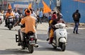 Indian men ride scooter and motor bicycle,waving hindu religious flags during Hindu god Hanuman, Jayanti shoba yatra or processio