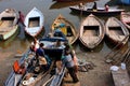 Indian men try to fix the motor of an old riverboat at the Ganges river dock