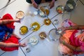 Hands of indian men and women having traditional gujarati thali lunch on floor for being of low caste