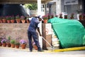 Indian men worker cleaner cleaning floor at patio park garden of department store at Delhi city morning before start thai festival