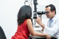 Indian middle aged professional ophthalmologist or optometrist man work at optometry clinic, using optometry instruments