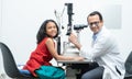 Indian middle aged professional ophthalmologist or optometrist man work at optometry clinic, using optometry instruments