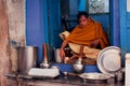 Indian milkman prepares the popular drink Lassi in fast-food store of historical city