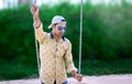 Indian Model standing in park holding swing chain