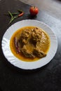 Indian mughal dish chicken chap prepared with big pieces of chicken meat in rich spicy gravy served in a white plate.