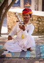 Indian musician in traditional dress playing musical instruments