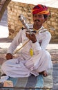 Indian musician in traditional dress playing musical instruments