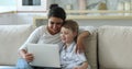 Indian nanny and little boy watch cartoons on laptop