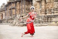 Indian odissi dancer striking pose against the backdrop of Ananta Basudeva temple