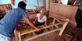 An indian old carpenter making sofa at sawmill factory