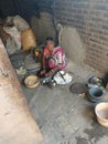 Indian old female making roti on chulha in small village