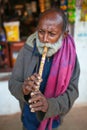 Indian old man blowing horn