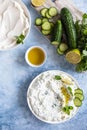 Indian or Pakistani raita sauce or dip with cucumber, yoghurt, garlic and mint, blue concrete background. Traditional Indian