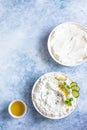 Indian or Pakistani raita sauce or dip with cucumber, yoghurt, garlic and mint, blue concrete background. Traditional Indian