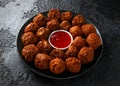 Indian Pakora snack spicy onion, red pepper with chilli sauce in a black plate