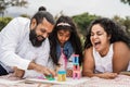 Indian parents having fun at city park playing with wood toys with their daughter - Main focus on mother face Royalty Free Stock Photo