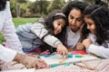Indian parents having fun at city park playing with wood toys with their daughter and son - Main focus on little girl face Royalty Free Stock Photo