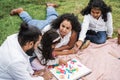 Indian parents having fun at city park playing with wood toys with their daughter and son - Main focus on mother face Royalty Free Stock Photo
