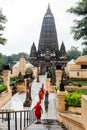 Indian people walking on bare foot to Mahabodhi Temple for pray and pilgrim while raining at Bodh Gaya, Bihar, India Royalty Free Stock Photo