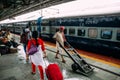 Indian people walking with his cart on platform for sending goods inside Howrah Junction railway station in Kolkata, India Royalty Free Stock Photo