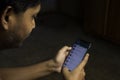 an Indian person is using whatsapp application in smartphone in a dark room with selective focus Royalty Free Stock Photo