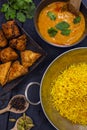 Indian pilau rice in balti dish served with chicken tikka masala curry and side dishes