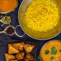 Indian pilau rice in balti dish served with chicken tikka masala curry and side dishes