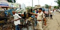 Indian police officer scolding rickshaw rider on road for cleaning traffic