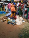 Indian Poor Mother and Child selling Coconut, Lime, Banana and Flowers or Puja Items in a Roadside near the Temple