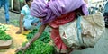 An Indian poor woman buying vegetable at farmers market Royalty Free Stock Photo