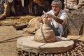 Indian potter making clay pots on pottery wheel in Bikaner. Rajasthan. India