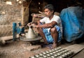 Indian potter making small pot or Diya for Diwali with clay on potters wheel in his small factory. Manufacturing traditional Royalty Free Stock Photo