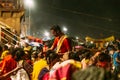 Indian priest blessing people in Varanasi Ganga Aarti at holy Dasaswamedh Ghat, near Kashi Vishwanath Temple while raining.