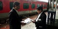 Indian railway ticket collectors talking together at station wearing black suit in india 2019