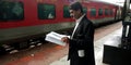 Indian railway ticket inspector standing at station waiting for train